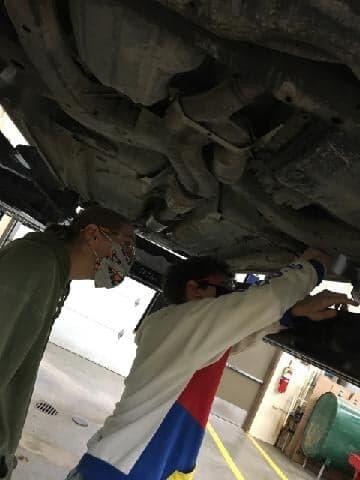 students working under vehicle
