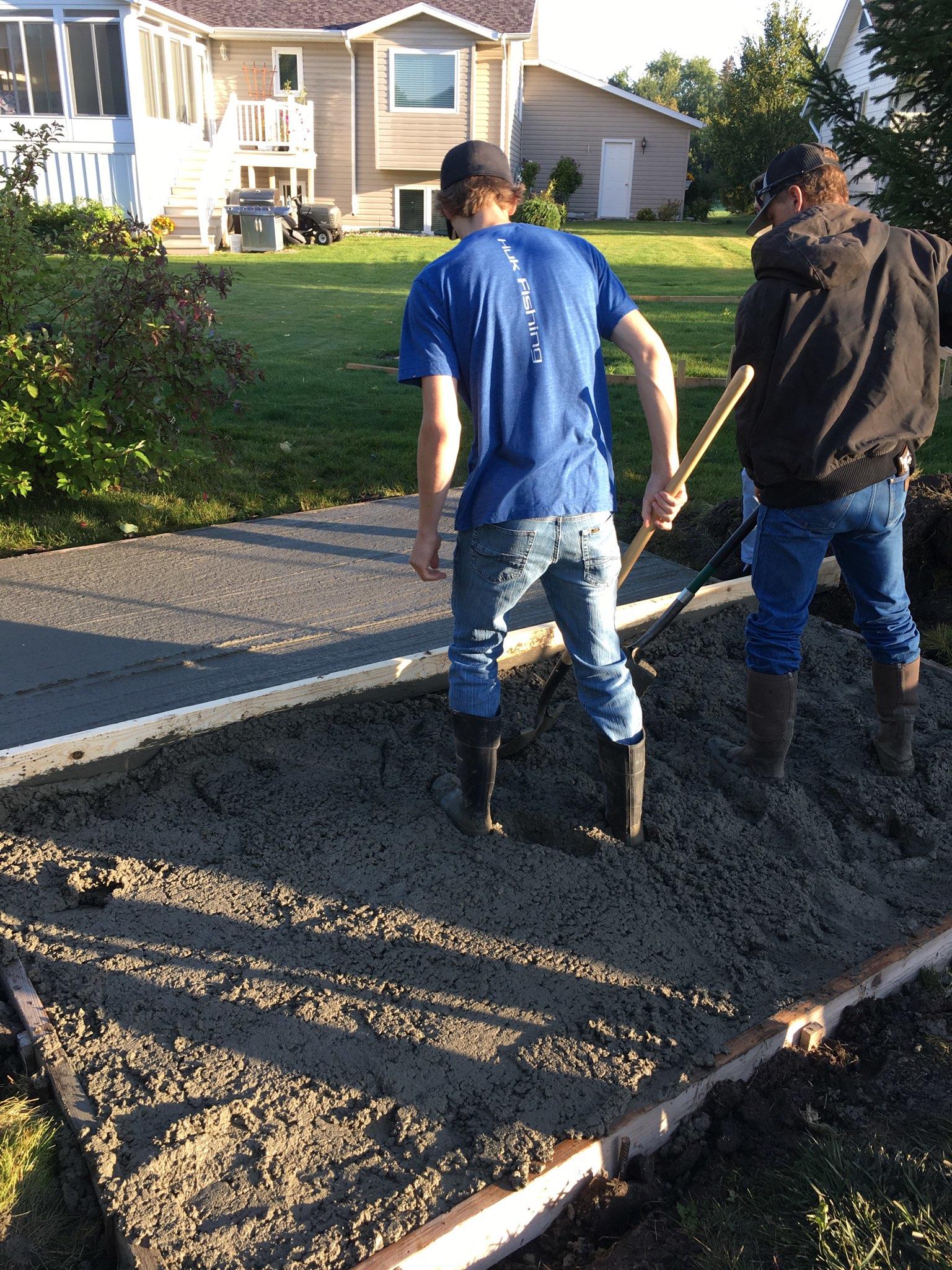 Students leveling an area of concrete.